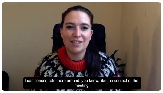 Person in patterned sweater in a video call with caption text.Person in patterned sweater in a video call with caption text.